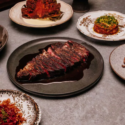 Baso Houston signature dishes Txuleton (Basque-style bone-in ribeye), Pork Chop, Grilled Oysters, Venison Tartare, Gambas al Ajillo, and various pintxos.